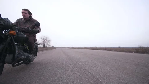 Close shot from below angel a dynamic moving biker on vintage motorcycle Stock Footage 154764055
