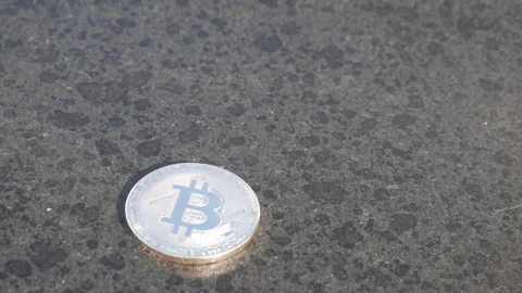 A close up shot of a bitcoin coin thrown on a table. Stock Footage 252458137