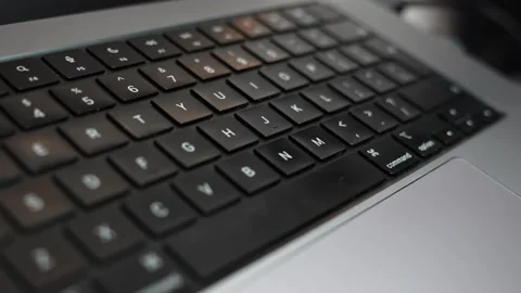Close-up shot of a black laptop keyboard in shallow focus, highlighting the Stock Footage 325361404