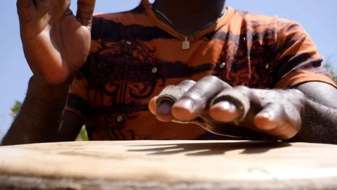 Close shot of black man playing djembe with plaster on finger Stock Footage 113165539