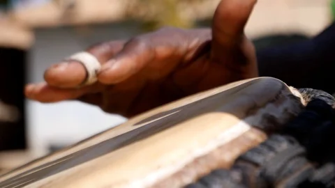 Close shot of black man playing djembe with plaster on finger Stock Footage 113165754