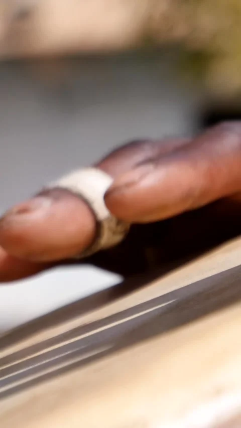 Close shot of black man playing djembe with plaster on finger Video stock 230663068