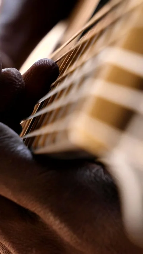 Close shot of black man playing acoustic guitar sitting on chair Stock Footage 230664515