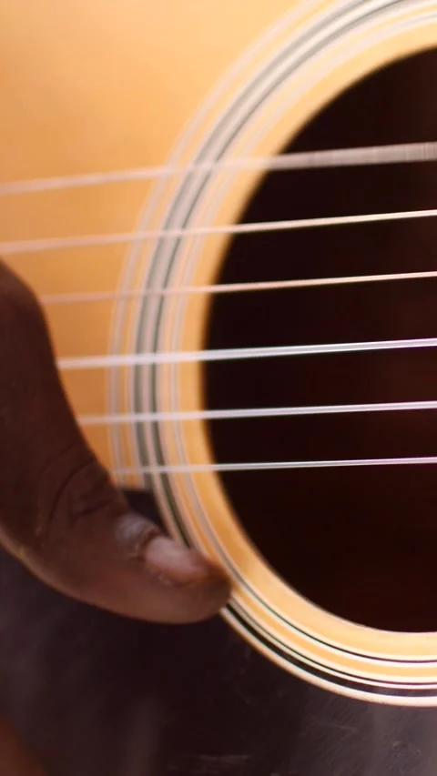 Close shot of black man playing acoustic guitar sitting on chair Stock Footage 230664690