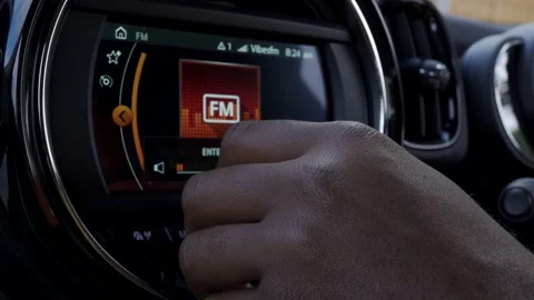 A close up shot of a black man turning up the voume on his car stereo Stock Footage 130708436