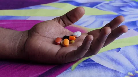 Close shot of a black man's hand opening the fist filled with a lot of medicines Stock Footage 147098517