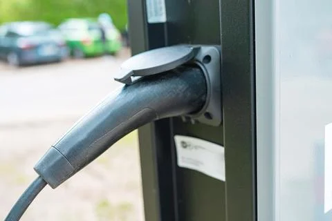 Close-up shot of a black plastic EV charging plug and handle connected to a Foto stock