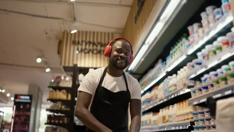 Close-up shot of a Black-skinned man in red headphones and a black apron dancing Stock Footage 247050876