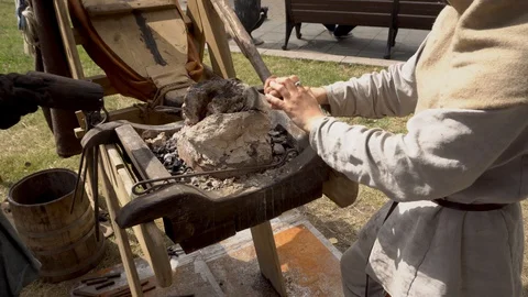 Close-up shot of a Blacksmith working old fashioned bellows at the fire. Stock Footage 130110042