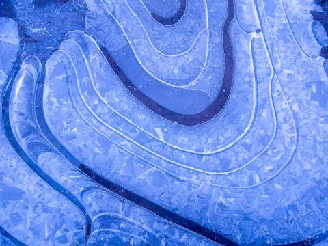 A close-up shot of a blue ice texture on a puddle in frosty winter weather Stock Photos