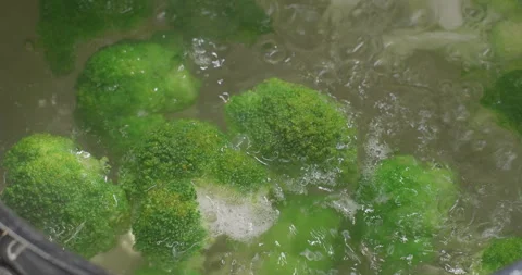 Close-up shot of boiling broccoli in a pot on induction stove. Slow motion Stock Footage 249982207