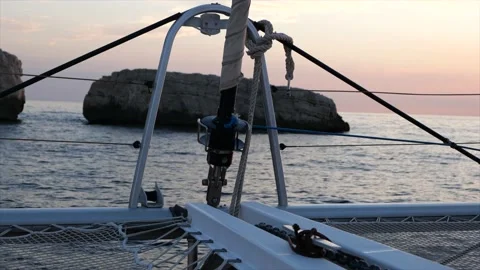 Close-up shot of the bow of a catamaran in front of the setting sun. Stock Footage 204922444