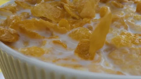 Close-up shot, Breakfast Cereal in a white bowl, corn flakes fall into a bowl, Stock Footage 131608810
