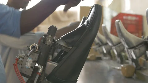 Close up shot of brushing a shoe on a mold in a shoe factory Stock Footage 108478233