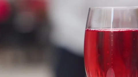 Close up shot of bubbling red beverage in clear glass with soft focus backg.. Stock-Footage 333775044
