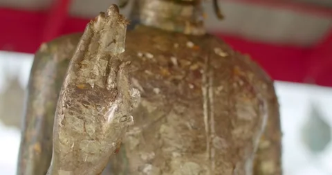 Close-up shot of the Buddha's hands covered in gold leaf by religious people. Stock Footage 223382494