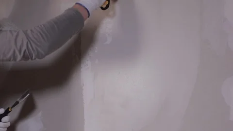 A Close Shot At The Builder Hands, Who Level The Wall With A Long Spatula Stock Footage 101382995