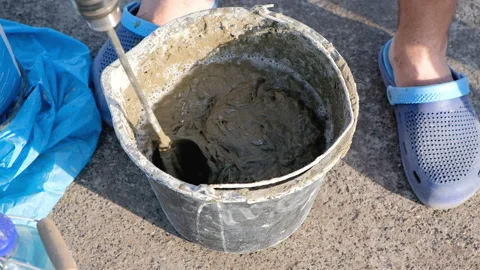 Close up shot of a builder mixing cement in a bucket on a constraction site Stock-Footage 89970069