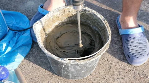 Close up shot of a builder mixing cement in a bucket on a constraction site Video stock 89970164