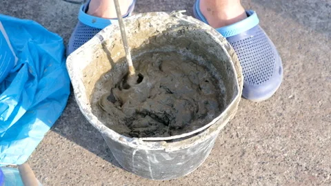 Close up shot of a builder mixing cement in a bucket on a constraction site Stock-Footage 89970271