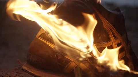 Close-up shot of Burning boots strong bright flame at summer night Slow motion Video stock 95909760