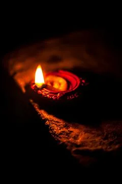 Close-up shot of burning Diva or divida or Diya or oil lamp isolated in dark. Foto stock