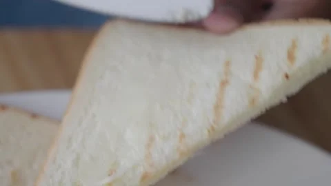 Close up shot of butter being spread on toasted bread with knife, food prep.. Stock Footage 332579471