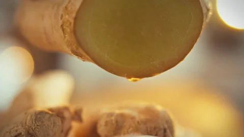 A close-up shot captures the freshly cut edge of ginger with juice droplets Stock Footage 331311241
