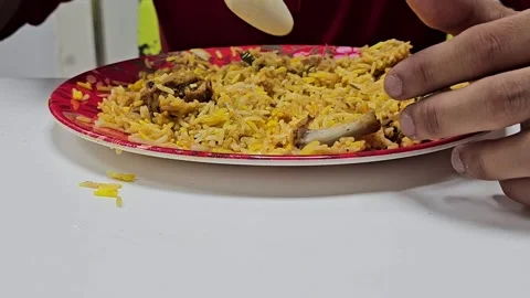 A close up shot captures hands reaching for a vibrant plate of yellow rice Video stock 311767122