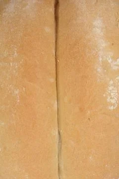 A close-up shot captures the textured surface of a white bread roll, highligh Stock Photos
