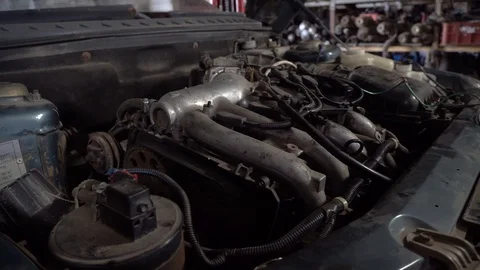 Close-up shot of a car engine under the hood in a car service. 库存影片 117125797