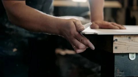 Close up shot of carpenter or joiner sanding wooden plank with sanding paper Stock-Footage 143452371