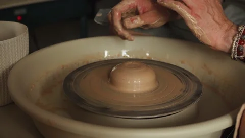 Close-up shot of ceramic cup spinning on potters's wheel and hands molding clay Stock Footage 158303511