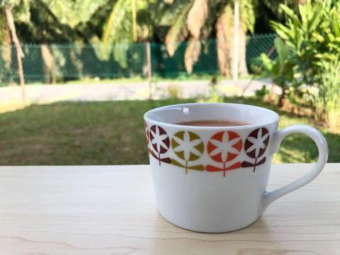 Close up shot of a ceramic white mug on the table with blurry background Stock Photos
