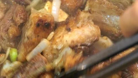 Close up shot of chef hand cooking meat in a frying pan. Cooking pork belly on a Stock Footage 221837171