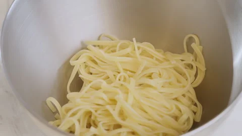 Close-up shot of chef puts spaghetti onto metal bowl in restaurant kitchen. Stock Footage 271613232
