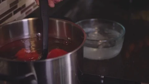 Close up shot of a chef scooping some tomatoes out of a cooking pot Video stock 83008346