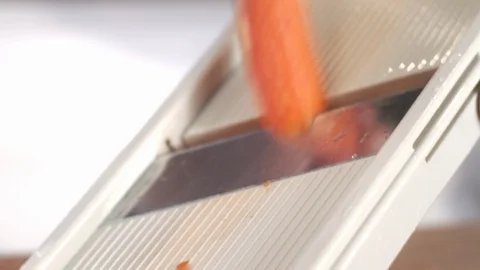 Close-up shot of chef slicing fresh carrot using mandolin Stock Footage 92196071