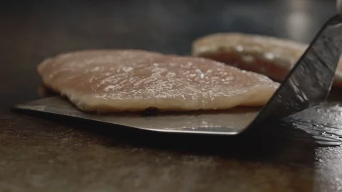 Close-up shot of chef turning over chicken breasts fried on grill pan Stock Footage 114429530