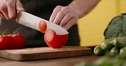 Close up shot of chef's hands using a knife cutting a fresh tomato on wooden Video stock 144447838