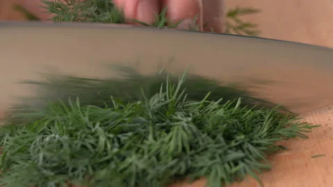 Close up shot of chef's hands using a knife cutting a dill Stock Footage 157418428