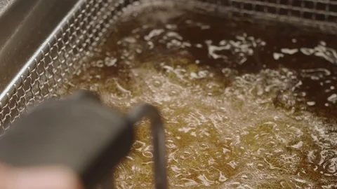 Close-up shot of chicken cutlets from deep-fried boiling oil. Slow motion video Stock Footage 113867477