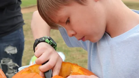 Close-up shot of a child carving the inside of a pumpkin Video stock 158681089
