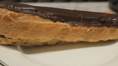 A close up shot of a chocolate eclair on a plate. Stock Footage 244340912