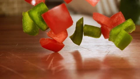 Close up shot of chopped pepper falling on a table in slow motion Stock Footage 152904567
