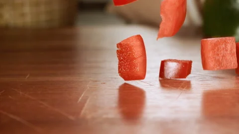 Close up shot of chopped red pepper falling on a table in slow motion Stock Footage 152904490