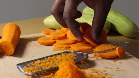 Close shot of a chopping board with sliced carrot pieces, shredded carrots Stock Footage 150371577