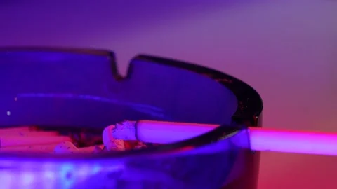 Close up shot of cigarette on table. Neon light on disco, party time and pers Stock Footage 172532538