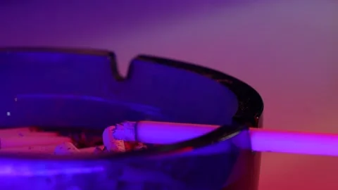 disco cigarette Close up shot of cigarette on table. Neo... | Stock Video