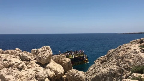 Close Shot of Cliffs vs Sea and a Tourist Boat in Cape Greco, Ayia Napa Stock Footage 91042219